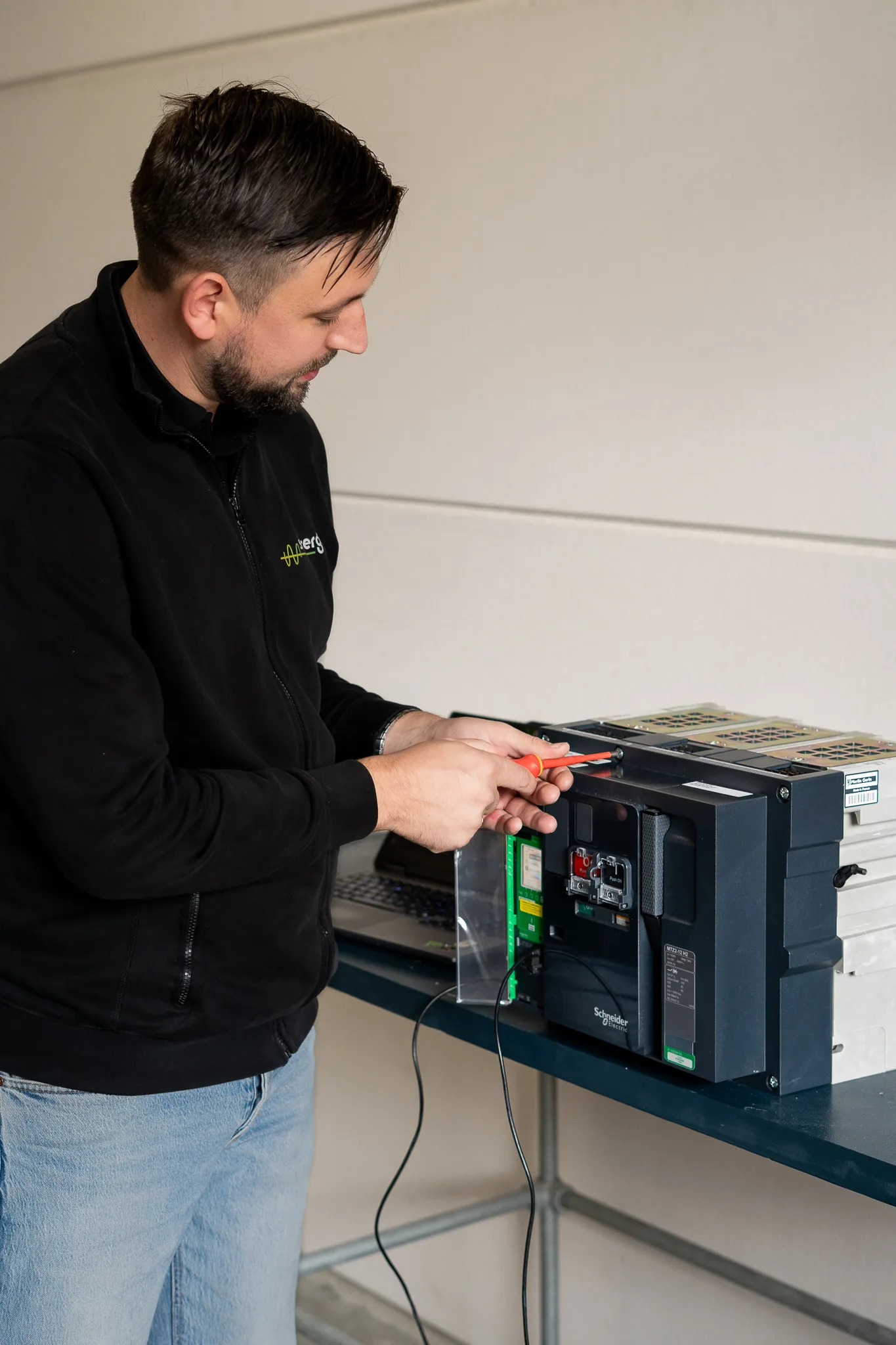 Sin-Ergy specialist working on a Schneider Electric circuit breaker